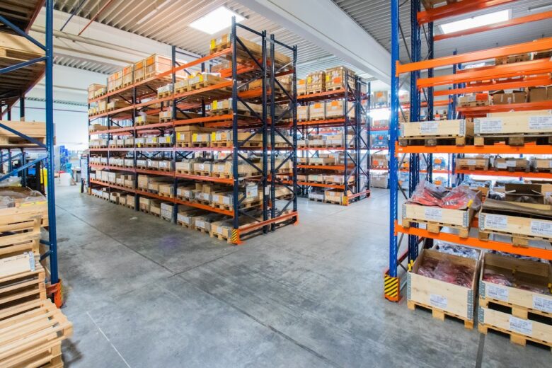 Innenansicht eines gut organisierten Lagers mit Metallregalen, die verschiedene Kisten und Paletten mit Produkten enthalten